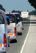 Imagen de fila de autobuses circulando por carretera